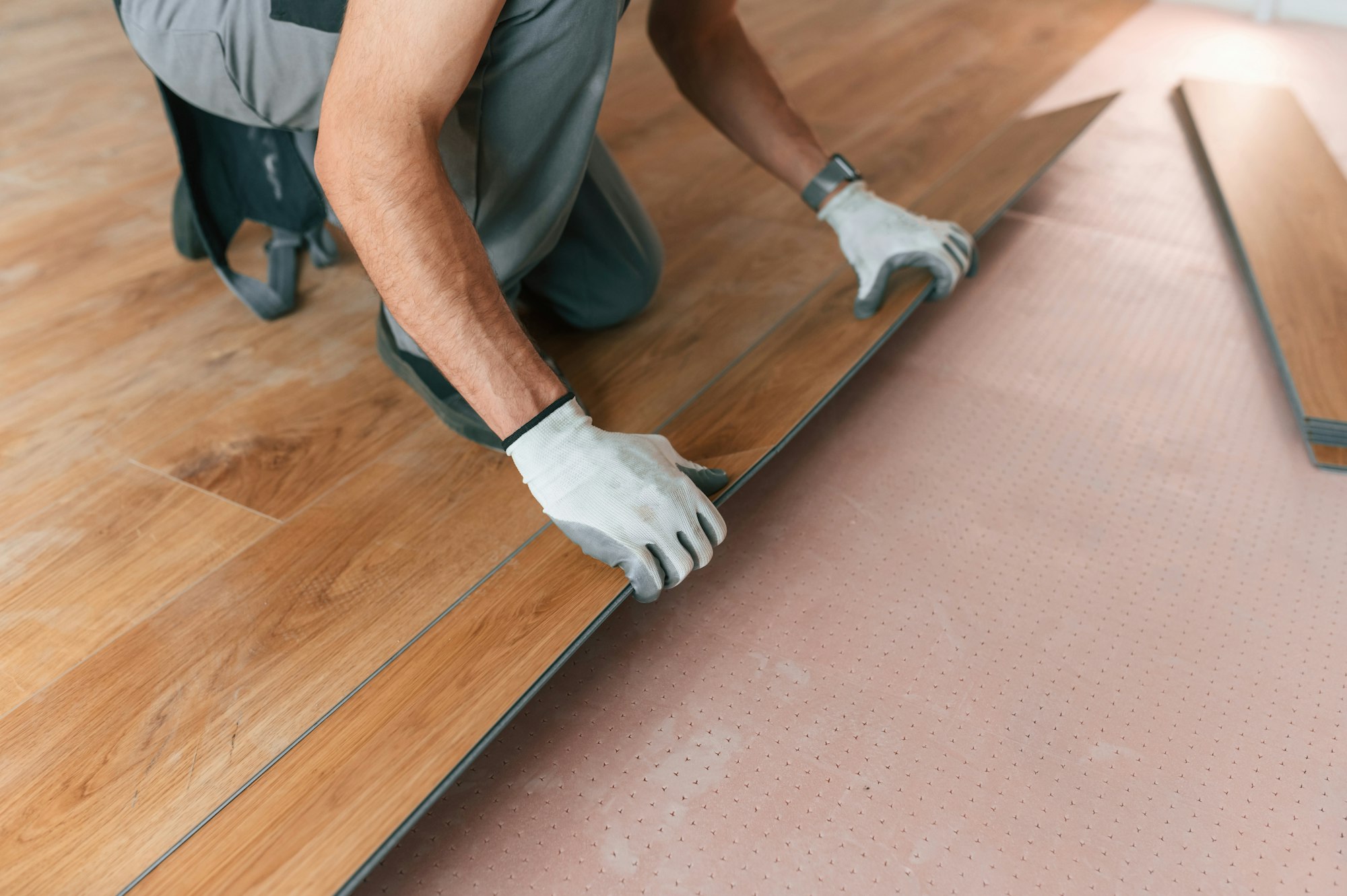 Man is installing new laminated wooden floor